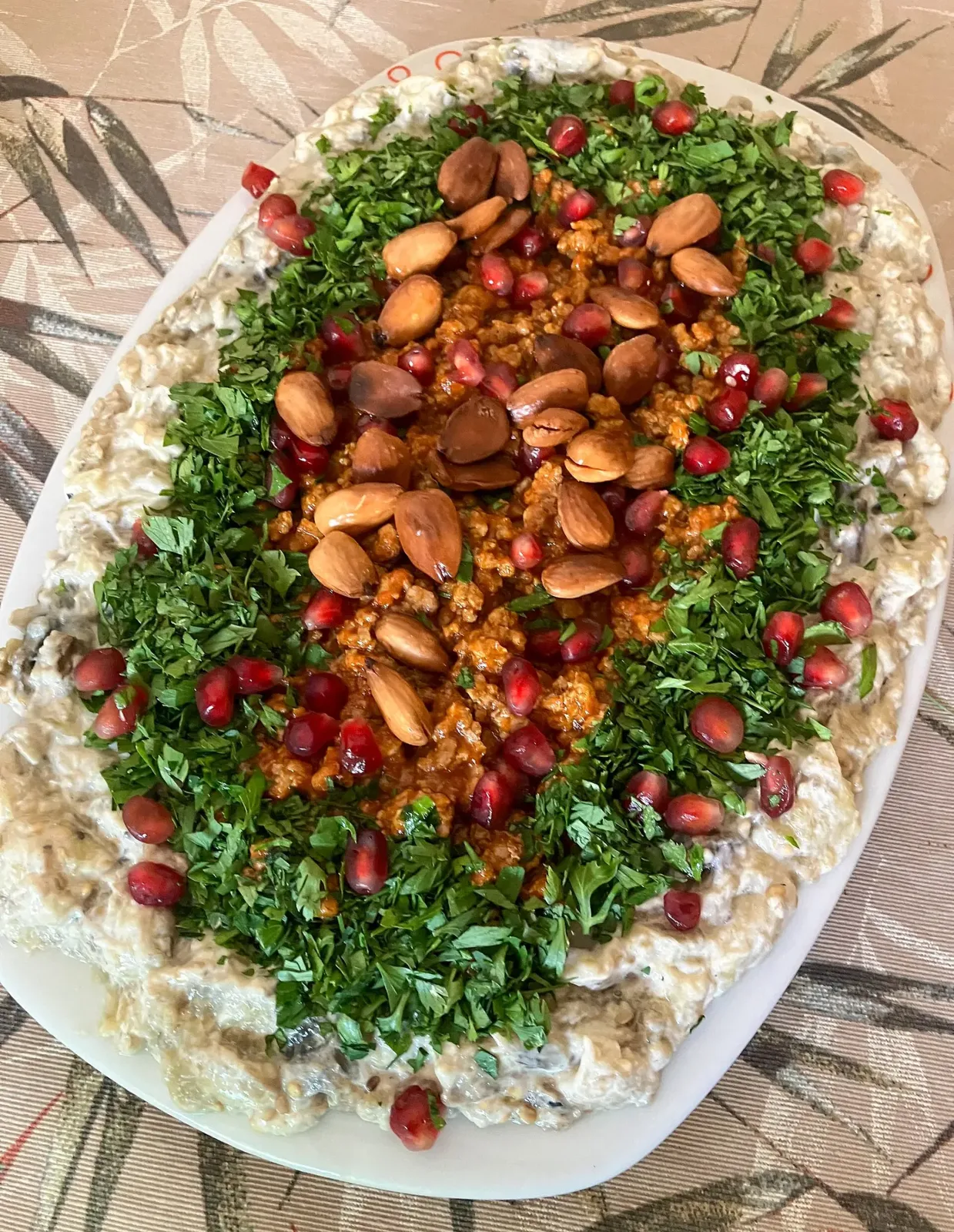 الباطرش: الباذنجانُ باللبن والطحينة، وفوقه اللحمُ والصنوبرُ وحبُّ الرمّان.
