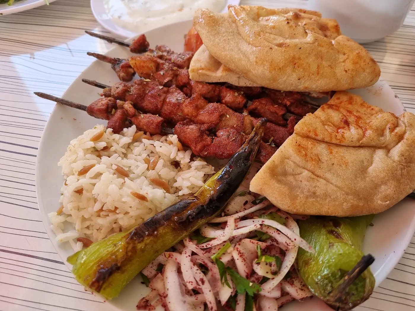 الكباب على الخبز مع البصل والسمّاق وحَبّ الرمّان: هكذا يُقدَّم في المشرق كلِّه.