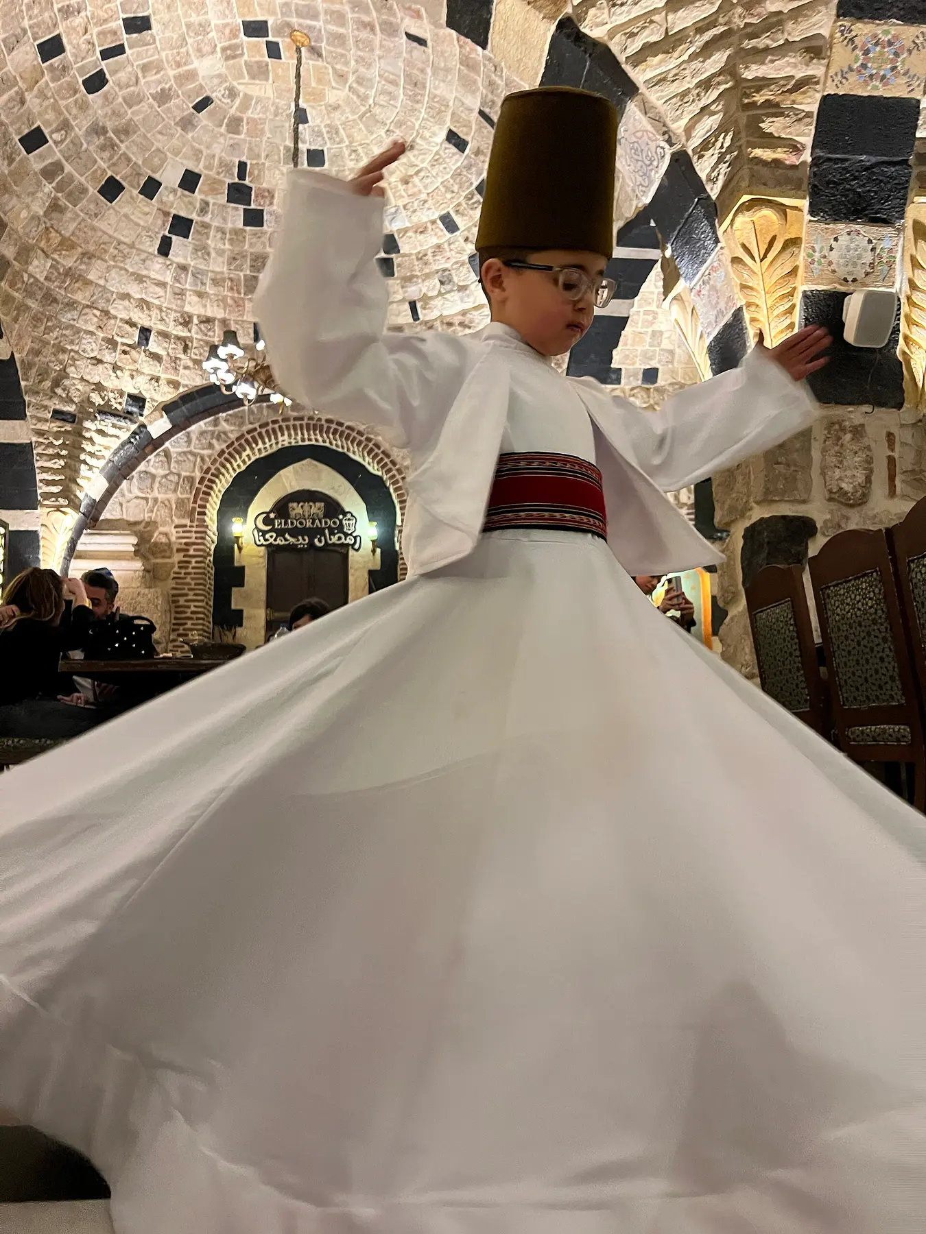 الدورانُ من زاويةٍ أخرى — الكفُّ اليمنى إلى الأعلى واليسرى إلى الأسفل، وهي وضعيّةٌ لها معنًى مقرَّر عند أهل الطريقة.