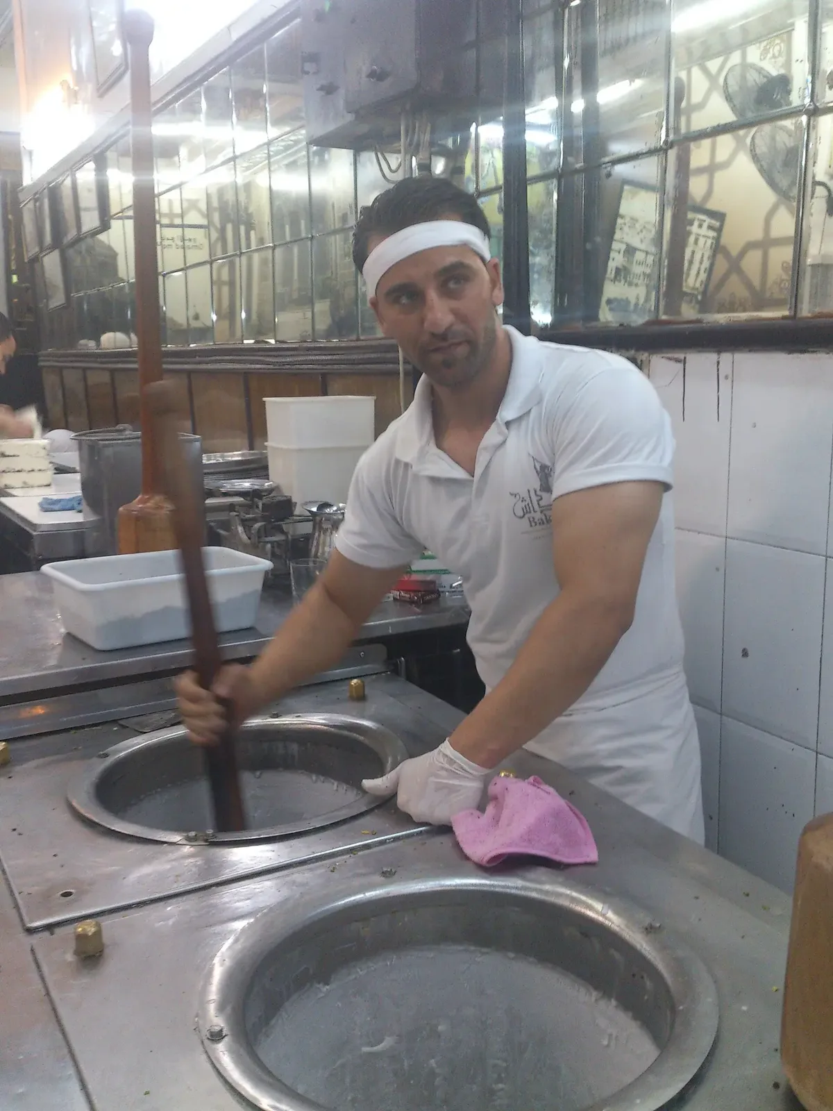 عامل بوظة يدقّ المزيج بالمهراس.