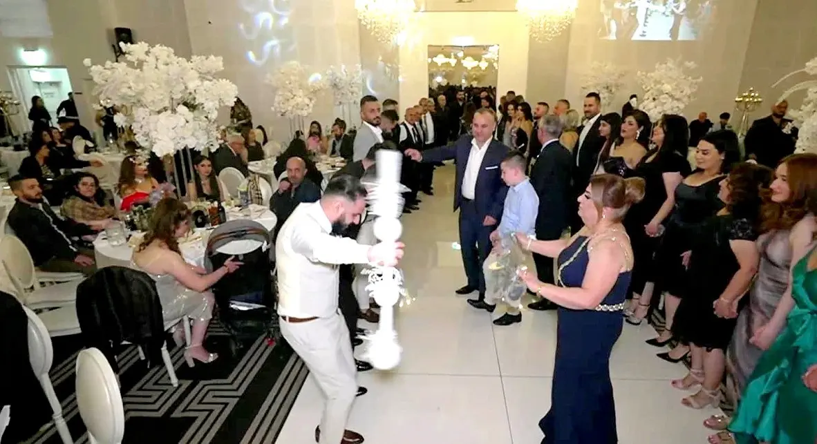 حلقةُ خݢا في عرسٍ أشوريّ، ورأسُ الحلقة يحمل العصا (قوبالا). (صورةٌ من المهجر.)